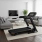 Black and orange folding treadmill with touch console display in modern living room setting