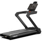 Black heavy-duty treadmill with digital console display, curved handrails, and M6.5 label on running deck, on white backgroun