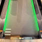 Treadmill running deck with bright green belt and gray side rails with textured grip surfaces, viewed from above