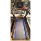 Black motorized treadmill with blue side rails, digital display console, and curved black handles, shown in showroom setting