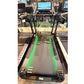 Black motorized treadmill with green-lit running deck, dual handles, and digital touchscreen console displaying workout inter