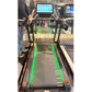 Black and green interactive treadmill with touch screen console, displayed at fitness showroom with person standing beside it
