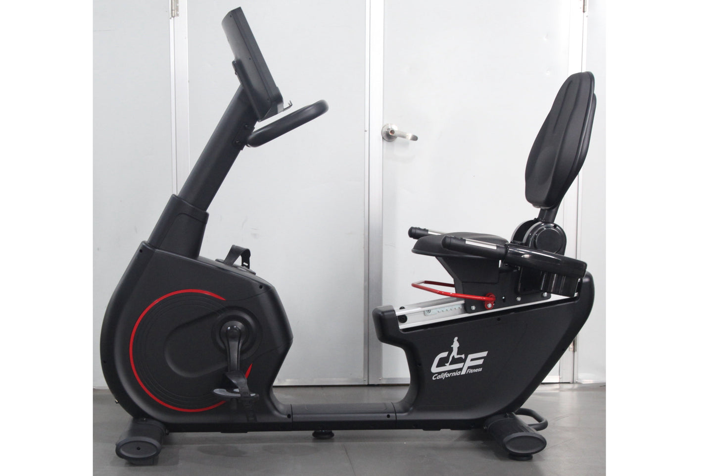 California Fitness RB8 black recumbent exercise bike with red accent wheel, padded seat, and adjustable backrest on white bac