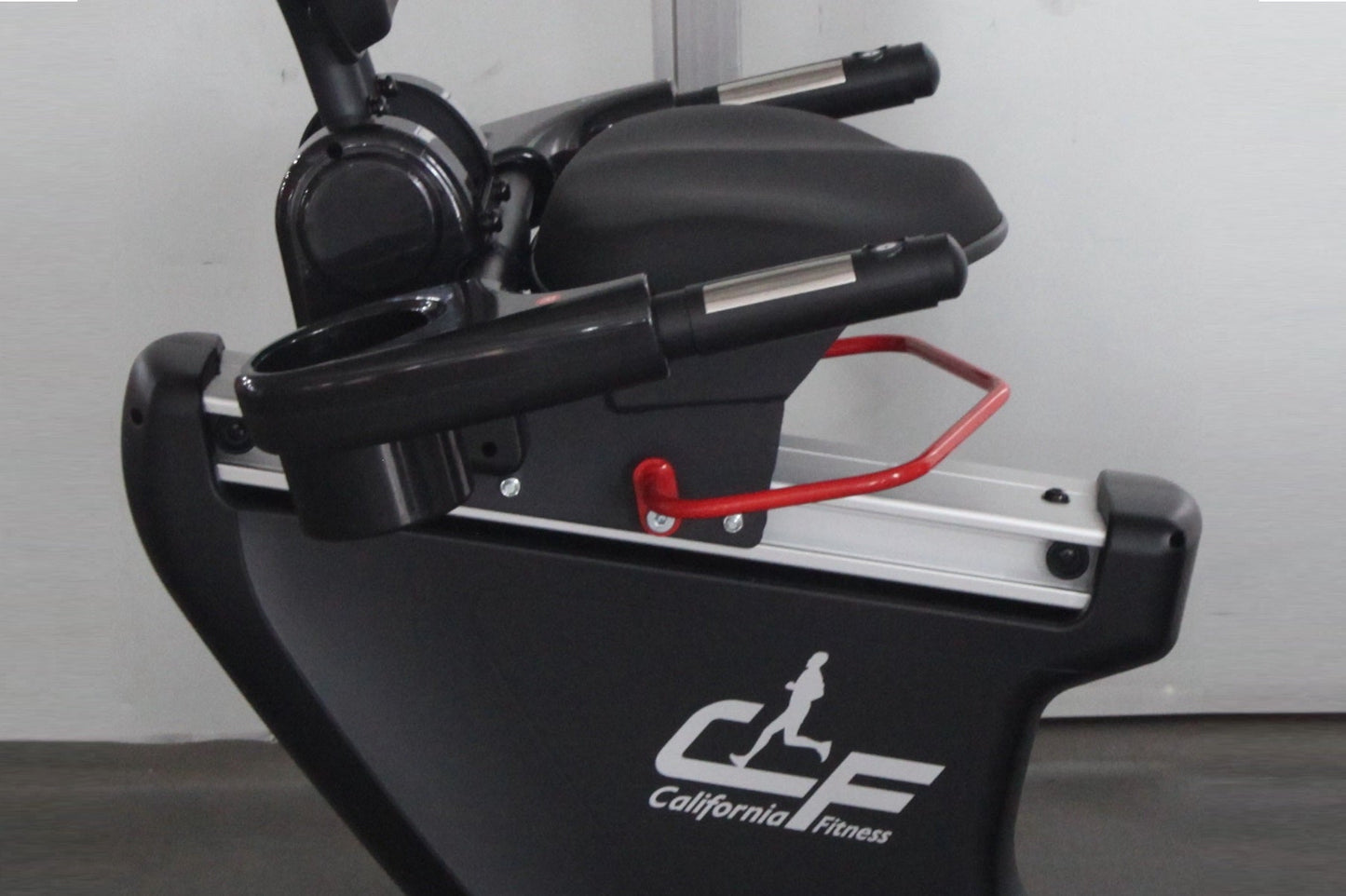 Black recumbent exercise bike with padded seat, handlebars with red safety handles, and silver frame details, displayed again