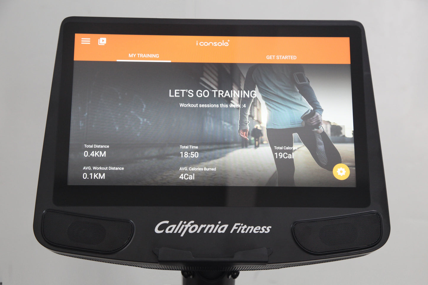 California Fitness E8i elliptical machine with orange and black console displaying training stats and runner image on screen
