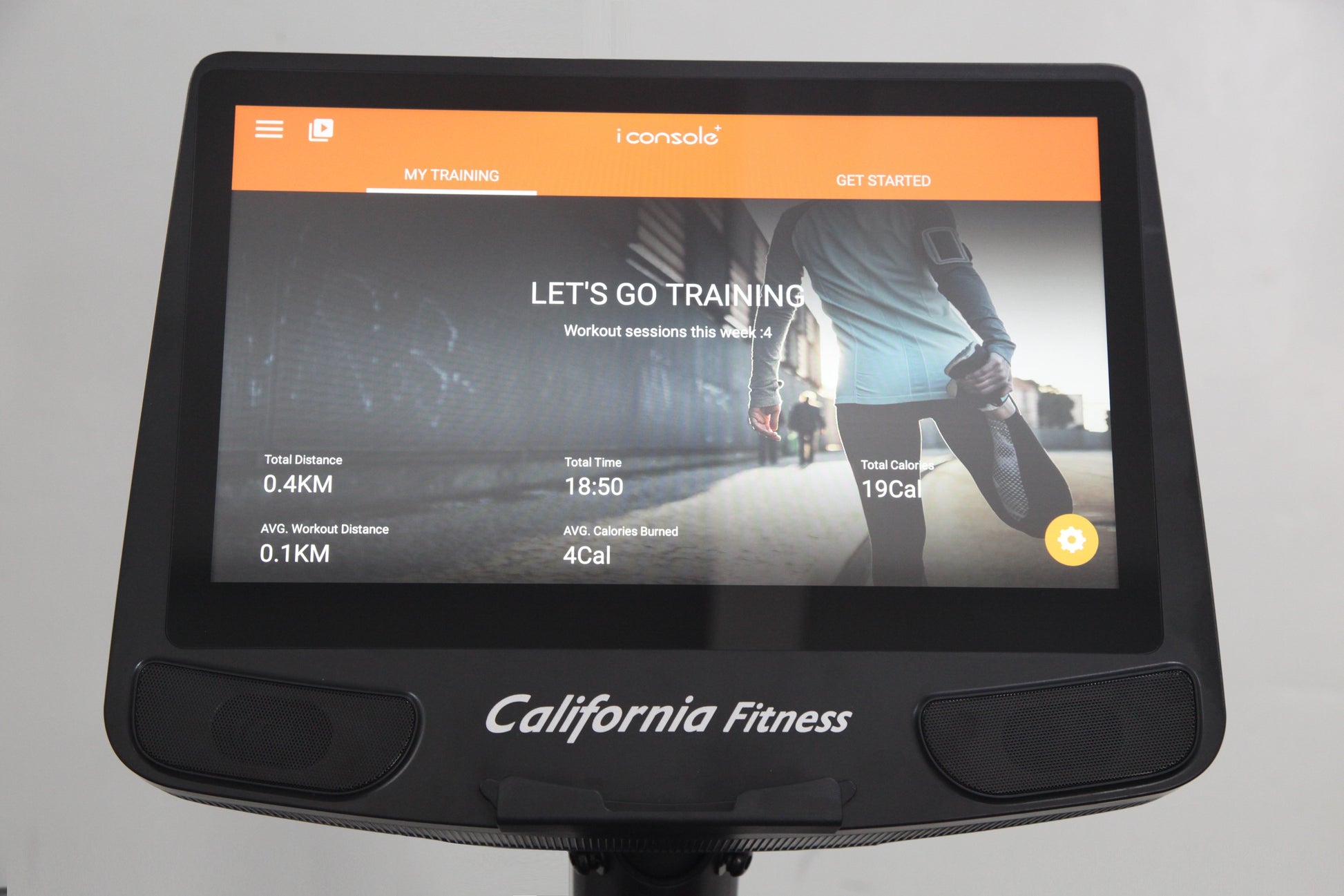 California Fitness E8i elliptical machine with orange and black console displaying training stats and runner image on screen
