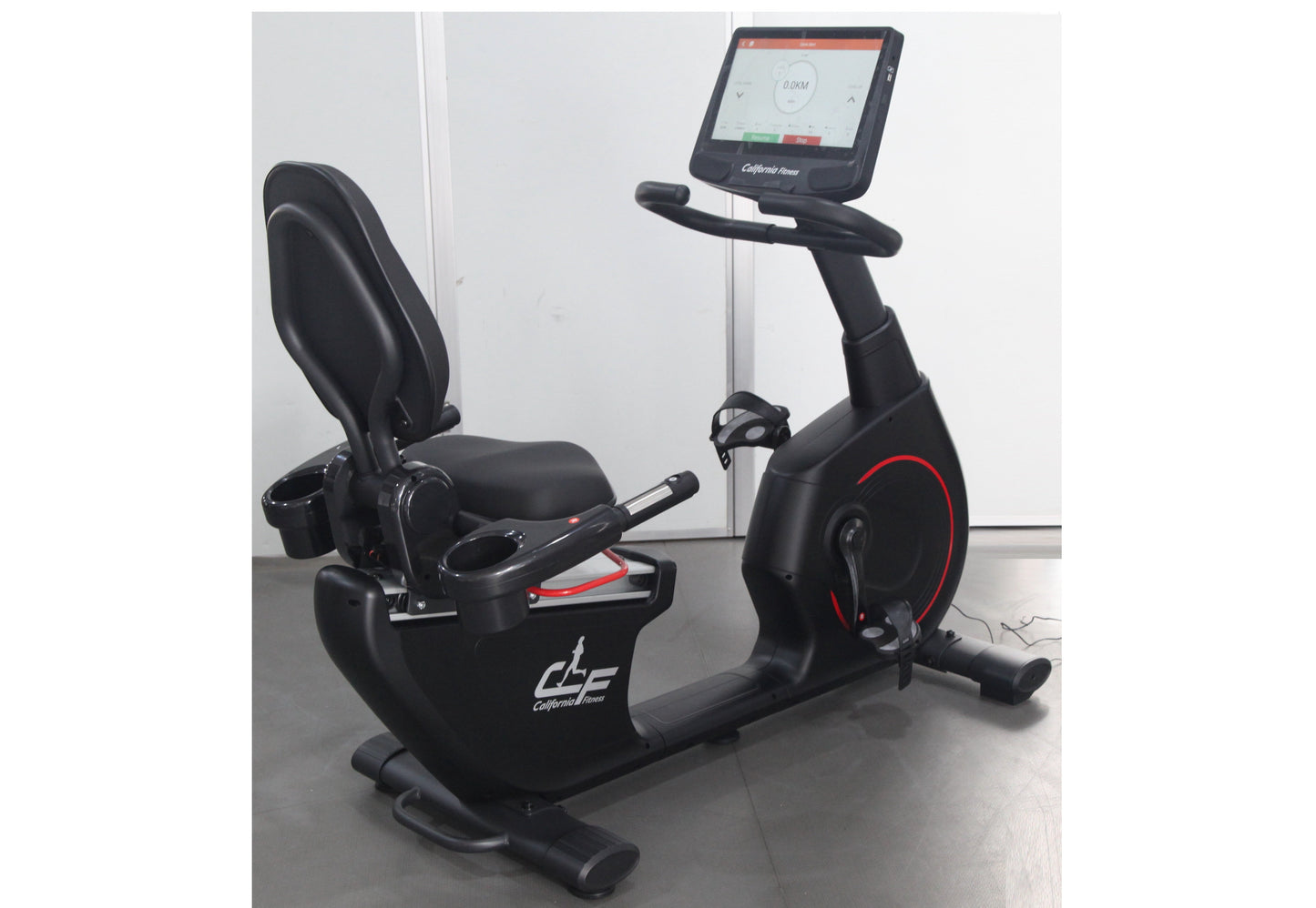 Black recumbent exercise bike with digital display console, padded seat, and red accent details on wheel