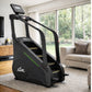 Black stair climber machine with digital display console, green accent stripe, and yellow steps in home gym setting