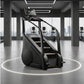 Black and gray stair climber stepmill with dual handrails, digital display monitor, and textured foot pedals in modern gym se