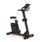 Black and dark brown upright exercise bike with digital display console, padded seat, and handlebar grips on white background