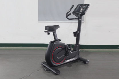 California Fitness U8 black upright exercise bike with red accents, digital display console, and padded seat on gray floor
