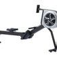 Black and white hybrid rowing machine with large fan wheel, extended seat rail, and foot pedals on white background