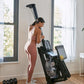Woman wearing rose-pink ribbed sports bra and matching leggings using black CityRow rowing machine in bright home gym with la