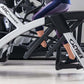 Person in purple leggings on white and black Cybex R Series Arc Trainer with digital display and foot pedals, side view