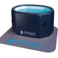 Dark navy inflatable cold plunge tub with turquoise water visible through clear top panel, sitting on gray mat with blue Dyna