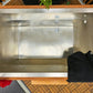Stainless steel cold plunge tub with wooden frame and white surround, viewed from above on wooden deck with plants and red cl