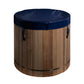 Cylindrical wooden cold plunge barrel with vertical wood slat construction, navy blue insulated cover, and black metal bands,