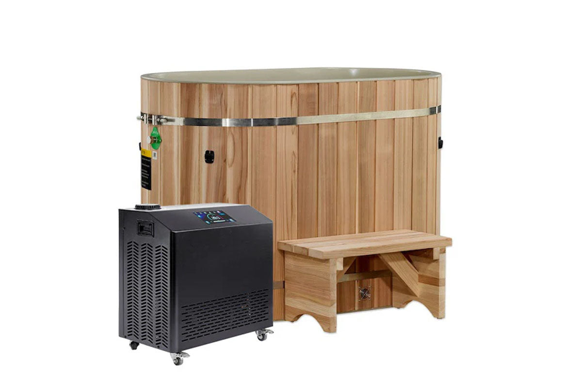 Oval wooden cold plunge tub with cedar construction, metal bands, and bench seat, paired with black chiller unit on wheels on