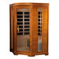 Golden cedar corner sauna with glass doors, carbon heating panels visible through windows, and wooden bench interior on white