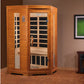 Two-person infrared sauna with golden cedar wood construction, glass doors with black interior panels, digital control panel,