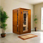 Wooden sauna cabin with cedar exterior and glass door showing infrared heating panels inside, displayed in home setting with 