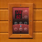 Digital control panel with wood frame mounted on sauna wall, displaying 128 degrees and 60 minutes in red LED text, with temp