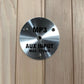 Brushed metal circular control panel with MP3 and AUX input specifications on light wood sauna exterior