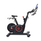 Black and red stationary exercise bike with digital display and adjustable handlebars on white background
