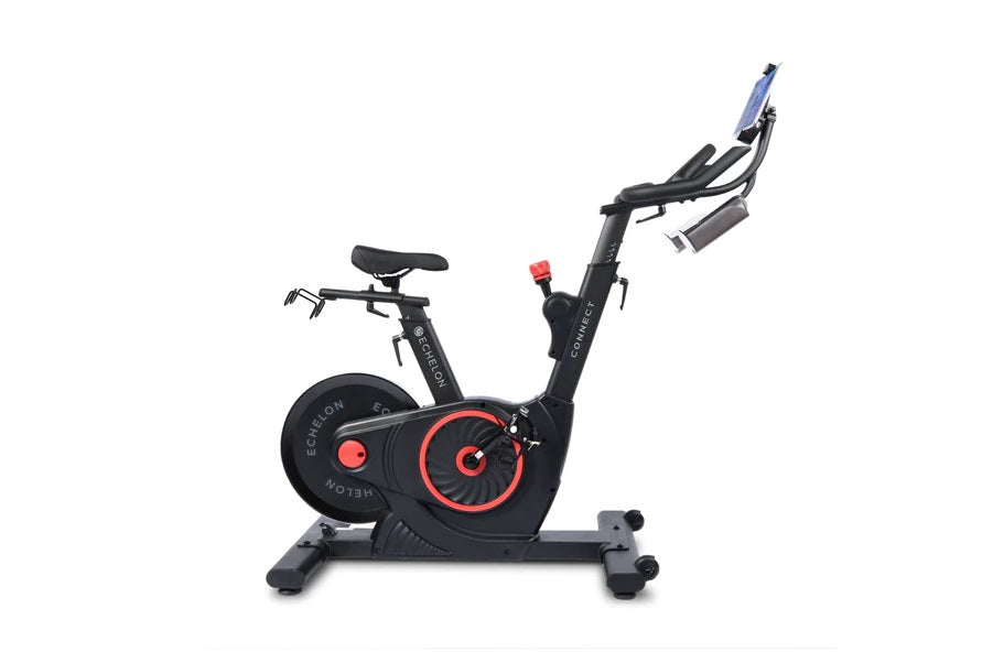 Black and red stationary exercise bike with digital display and adjustable handlebars on white background