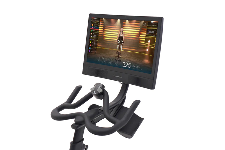 Black stationary indoor exercise bike with curved handlebars and digital display screen showing cycling metrics and fitness a