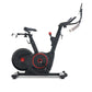 Black and red indoor stationary exercise bike with dual handlebar options and weighted flywheel on white background