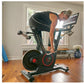 Man using black Echelon Connect stationary bike with red accents and tablet display in home gym setting