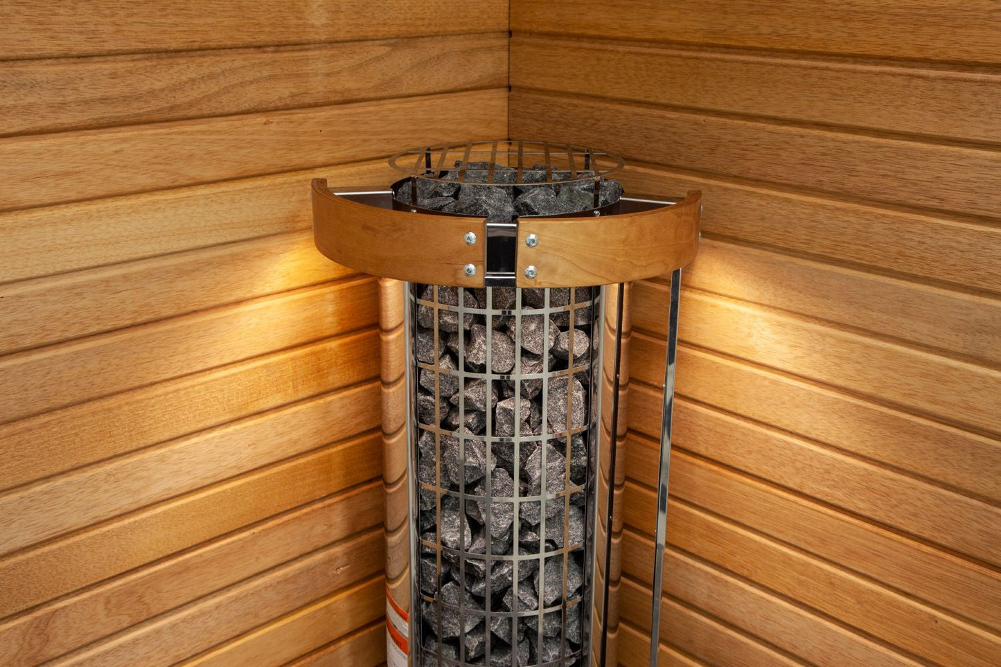Harvia Cilindro electric sauna heater with metal grill basket filled with gray stones, wood band collar, and control dial, in