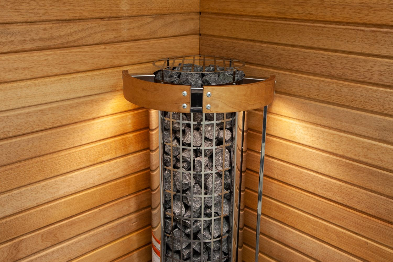 Harvia Cilindro electric sauna heater with metal grill basket filled with gray stones, wood band collar, and control dial, in