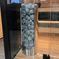 Harvia Cilindro electric sauna heater with black metal cage filled with gray stones, stainless steel base, displayed in showr