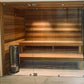Harvia Cilindro cylindrical electric sauna heater with built-in dial controls, displayed in wooden sauna room with glass door