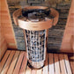 Harvia Cilindro electric sauna heater with black metal basket and light wood band, installed in sauna room with wooden walls 