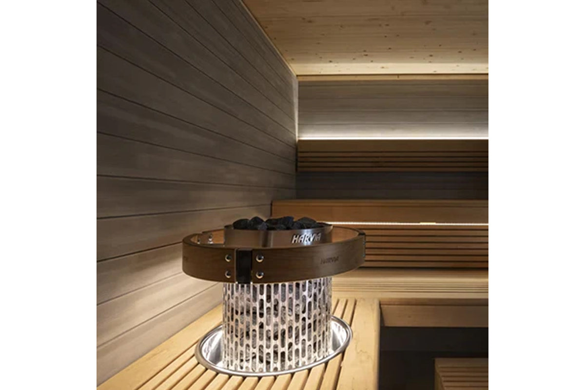 Harvia Cilindro electric sauna heater with white perforated steel body, brown leather belt band, and built-in controls on woo
