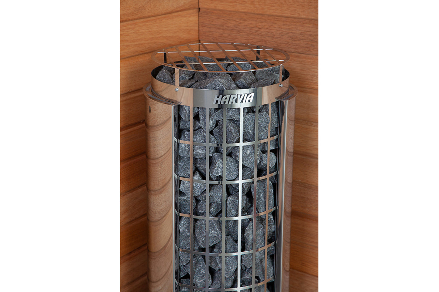 Harvia Cilindro electric sauna heater with stainless steel cage filled with gray stones, wooden sauna interior background