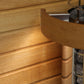 Tan leather sauna bucket with stainless steel handle and metal rivets, positioned on wooden sauna bench