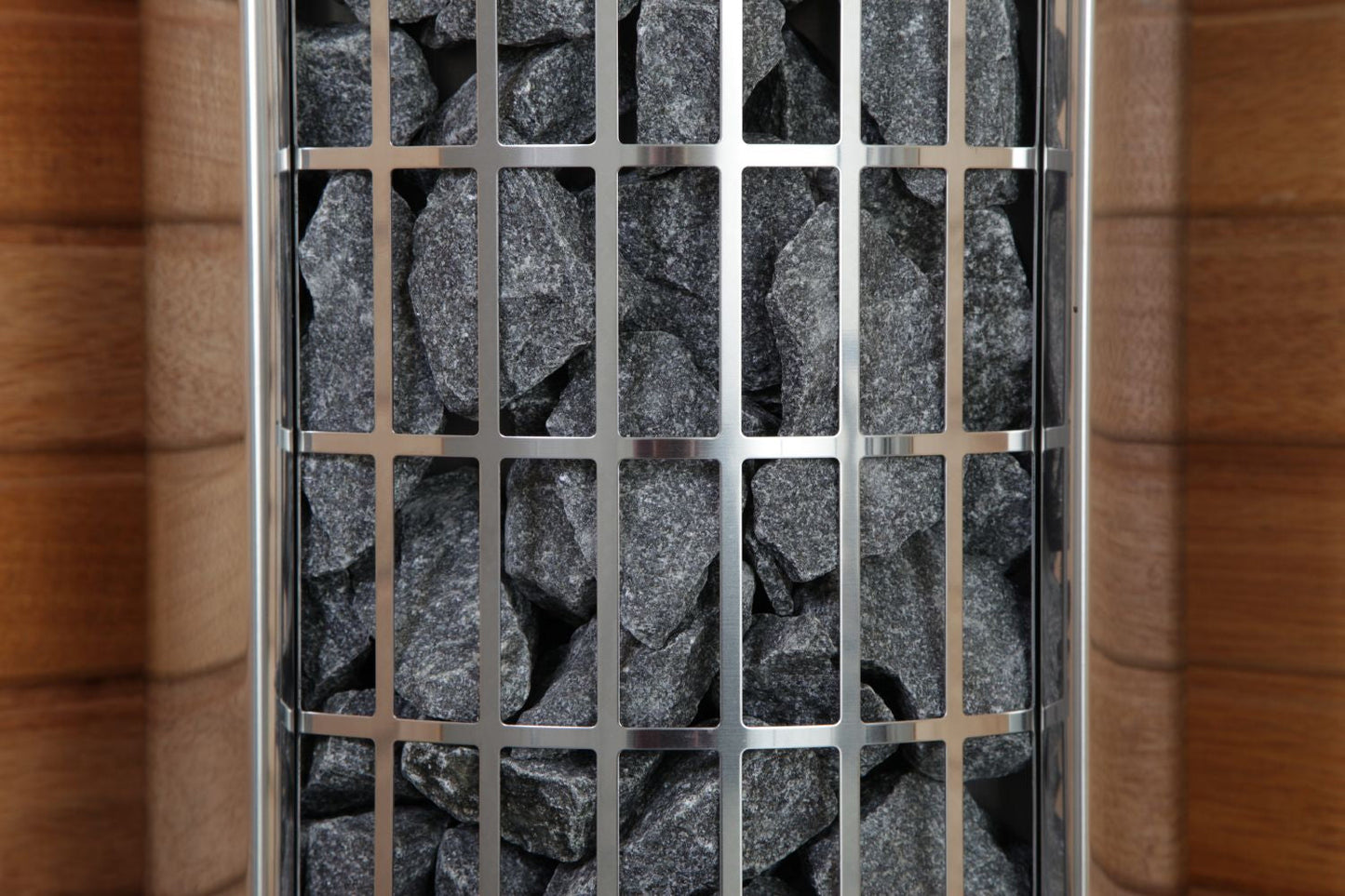 Harvia Cilindro electric sauna heater with stainless steel grid panel covering dark gray stones inside cylindrical chamber