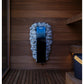 Harvia Spirit electric sauna heater with blue metal casing mounted on wooden sauna wall surrounded by grey stones