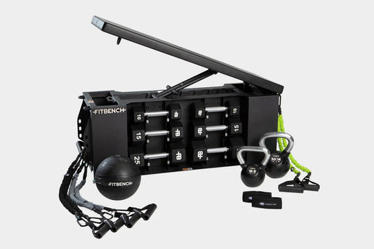 Black FITBENCH ONE weight bench with hinged storage top, dumbbell set, kettlebells, resistance bands, and suspension trainer 