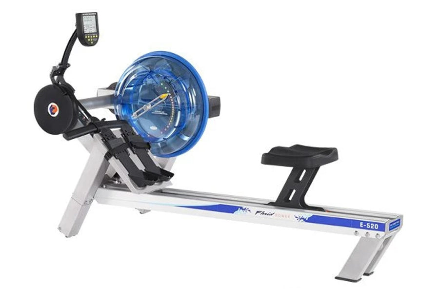 FluidRower E520 commercial fluid rowing machine with blue resistance wheel, black seat, digital monitor, and white base on wh