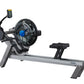 FluidRower E550 rowing machine with gray frame, black seat, blue resistance wheel, and digital monitor display on white backg