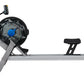 FluidRower E550 rowing machine with black and gray frame, blue resistance dial, and digital monitor on white background