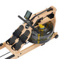 FluidRower Viking 2 Plus Select rowing machine with natural wood frame, black footplates, digital monitor, and clear fluid re