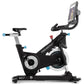Freemotion CoachBike indoor cycle with black frame, white flywheel, blue accents, upright handlebars, and tablet holder displ