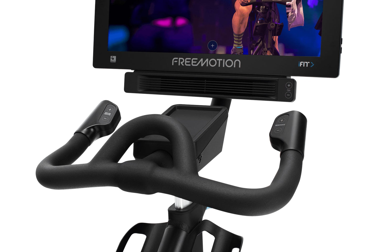 Freemotion CoachBike indoor cycle with black padded handlebars, seat, and base, Freemotion monitor displaying fitness content