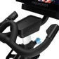 Black stationary exercise bike with padded handlebars, tablet holder, and digital console displayed with screen and remote co